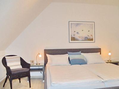 Schlafzimmer mit Doppelbett und Sessel