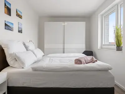 Schlafzimmer mit Doppelbett und Kleiderschrank