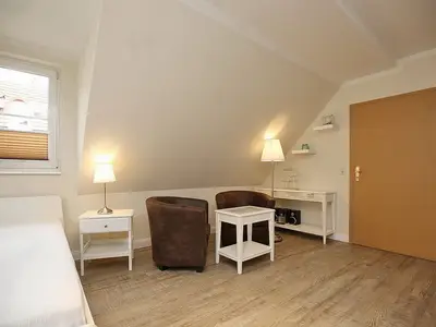 Wohnzimmer mit Doppelbett und Sitzgruppe