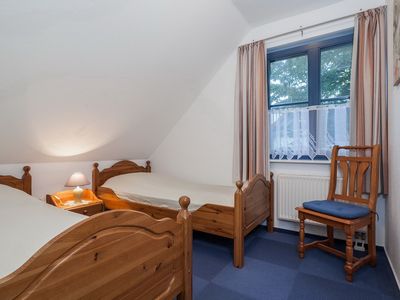 erstes Schlafzimmer mit Einzelbetten und Stuhl