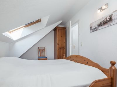 zweites Schlafzimmer mit Doppelbett, Kleiderschrank und Stuhl