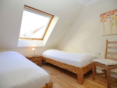 erstes Schlafzimmer mit Einzelbetten und Stuhl