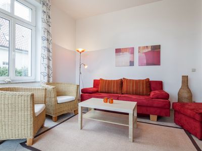 Wohnzimmer mit Schlafcouch und Sessel