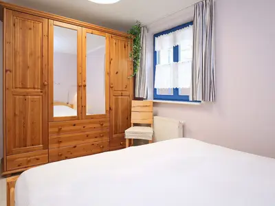 Schlafzimmer mit Doppelbett und Kleiderschrank