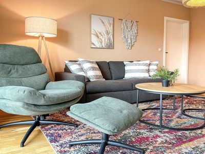 Wohnzimmer mit Schlafsofa und Sessel