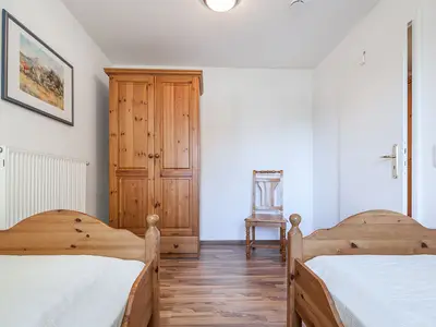 Schlafzimmer mit Einzelbetten und Kleiderschrank