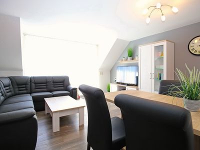 Ecksofa mit TV und Esstisch im Wohnzimmer