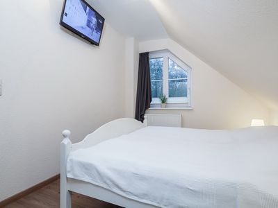 zweites Schlafzimmer mit Doppelbett und TV