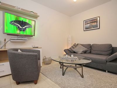 Wohnzimmer mit Schlafcouch und Fernseher