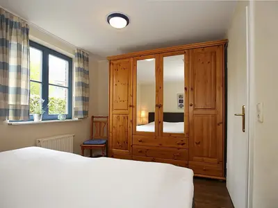 Schlafzimmer mit Doppelbett und Kleiderschrank