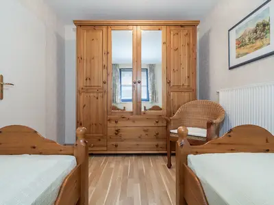 Schlafzimmer mit Einzelbetten und Kleiderschrank