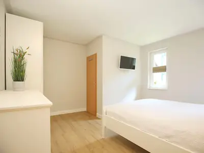 TV und Kleiderschrank im ersten Schlafzimmer