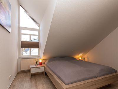 Schlafzimmer mit Doppelbett und Kleiderschrank