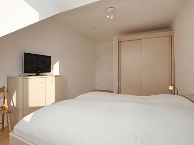 erstes Schlafzimmer mit Kleiderschrank und TV