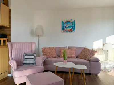Wohnzimmer mit Schlafsofa und Sessel