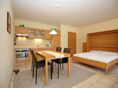 Wohnzimmer mit Esstisch und Schrankbett