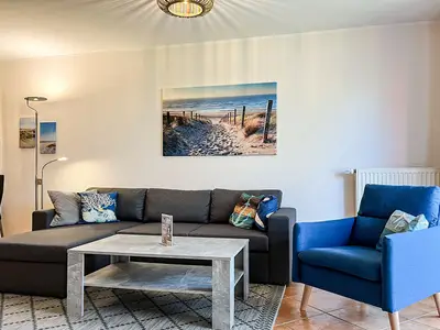 Wohnzimmer mit Schlafsofa und Sessel
