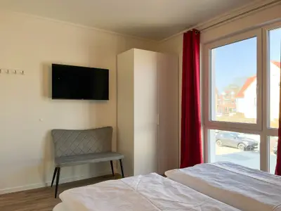 erstes Schlafzimmer mit Doppelbett und Kleiderschrank