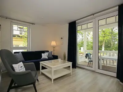 Wohnzimmer mit Schlafcouch und Sessel