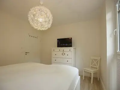 Schlafzimmer mit Doppelbett und TV