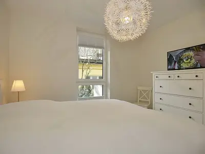 Schlafzimmer mit Doppelbett und TV