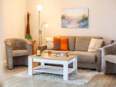 Wohnzimmer mit Schlafsofa und Sessel