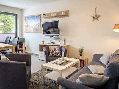 Wohnzimmer mit Schlafcouch und Fernseher