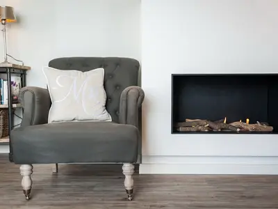Wohnzimmer mit Sessel und Kamin