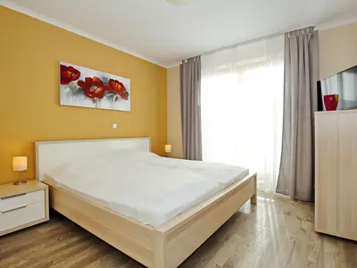 Schlafzimmer mit Doppelbett und TV