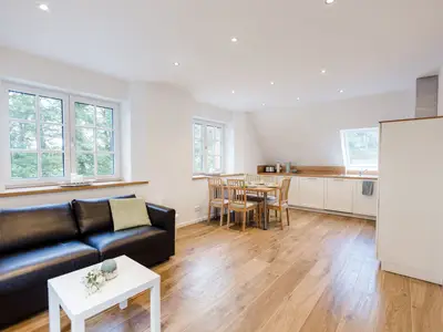 gemütliches Sofa mit Esstisch und Küche im Hintergrund