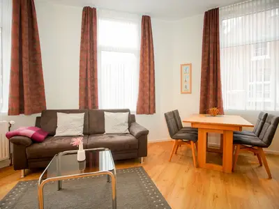 Sofa vor Fenster und Esstisch mit Stühlen