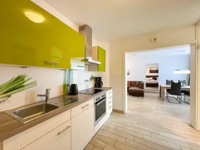 Küchenzeile mit Blick zum Wohnbereich und weiter in ein Schlafzimmer