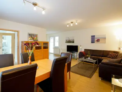 Wohnzimmer mit Blick auf Esstisch, Sideboard, TV und Sofa, in Richtung Terrassentür