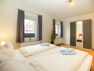 Zweites Schlafzimmer, Blick vom Bett zum Schrank und zu den Fenstern