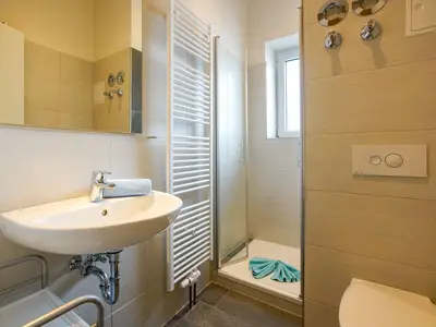 Badezimmer mit WC, Waschbecken und Dusche