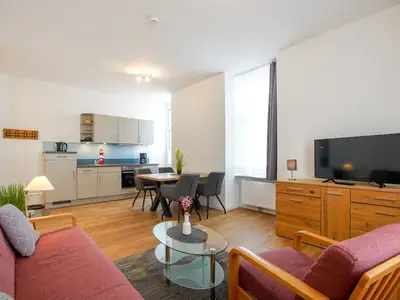 Blick vom Sofa Richtung Esstisch mit vier Stühlen und Küchenzeile