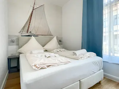Schlafzimmer mit Fototapete eines Schiffes, Boxspringbett