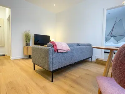 Wohnzimmer mit Blick auf Sofa, Sideboard und TV