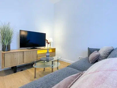 Blick über das Sofa in Richtung Sideboard und TV