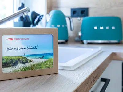 Postkarte auf Küchenzeile mit türkisfarbenen Wasserkocher und Toaster..