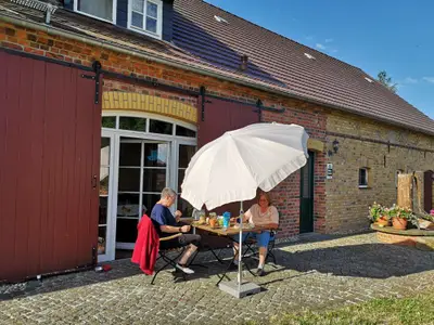 Terrasse mit Sitzgelegenheit und Sonnenschirm