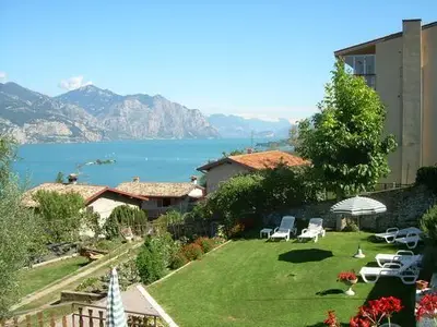 Garten mit Liegestuehlen, Sonnenschirme und Seeblick