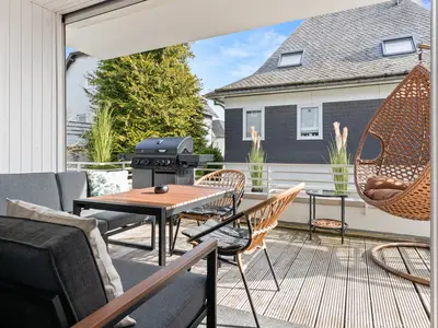 Balkon an der Küche mit Gasgrill und Loungemöbeln