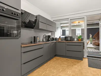 Balkon an der Küche mit Gasgrill und Loungemöbeln