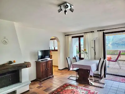 Wohn- und Esszimmer mit TV und Eingang zur Küche sowie Ausgang auf die Terrasse