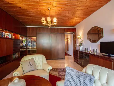 Ostsee Lodge – stilvoller Wohnbereich mit TV und gemütlichen Sesseln, Ferienwohnung am Strand von Brodau.