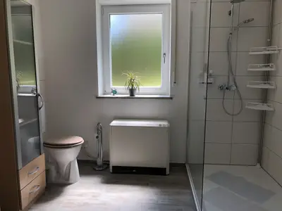Bad mit Rainshower Dusche und erhöhtem Toilettensitz