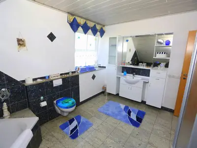 Badezimmer mit Badewanne und Dusche