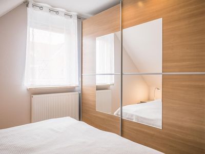Schlafzimmer mit Kleiderschrank und Fenster