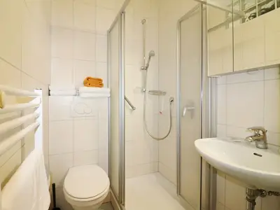 Badezimmer mit Dusche und Waschbecken mit Spiegel inkl.Handtüchern